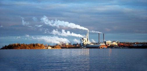 Industrihamn med rykande skorstenar